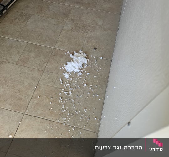 שאריות חומר על רצפה, מטאטא בפינה
